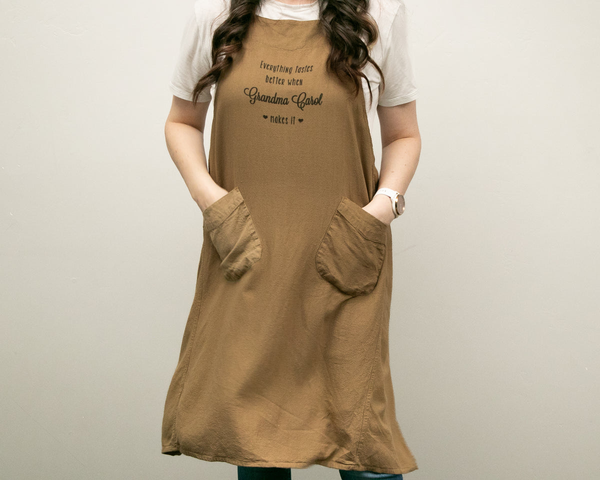 a woman wearing a brown dress with her hands in her pockets