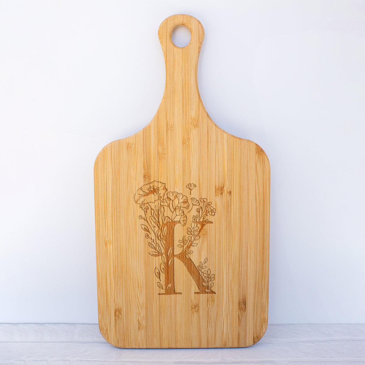 a cutting board with the letter k on it