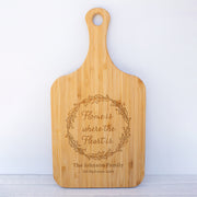 a cutting board with the words home is where the heart is