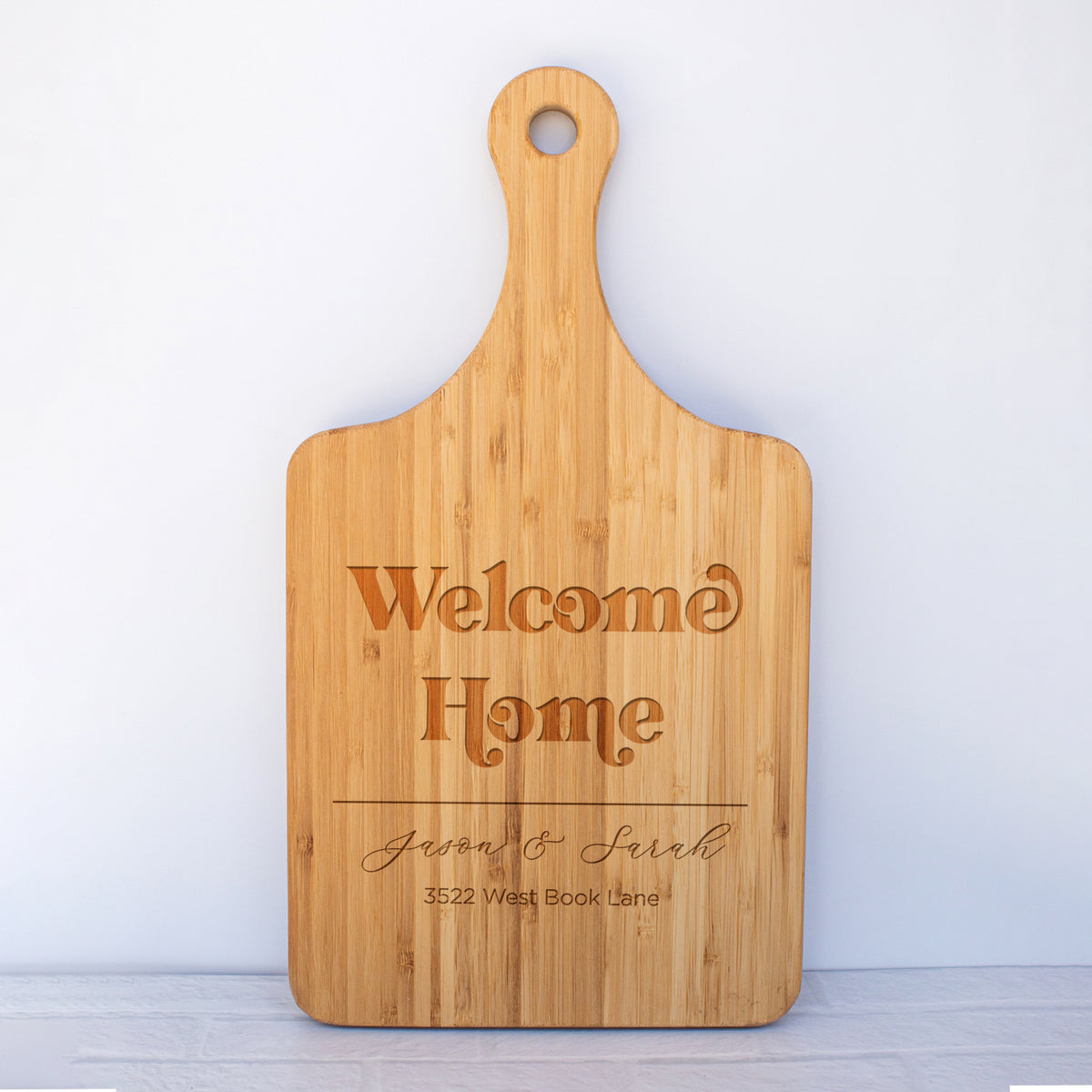 a wooden cutting board with the words welcome home on it