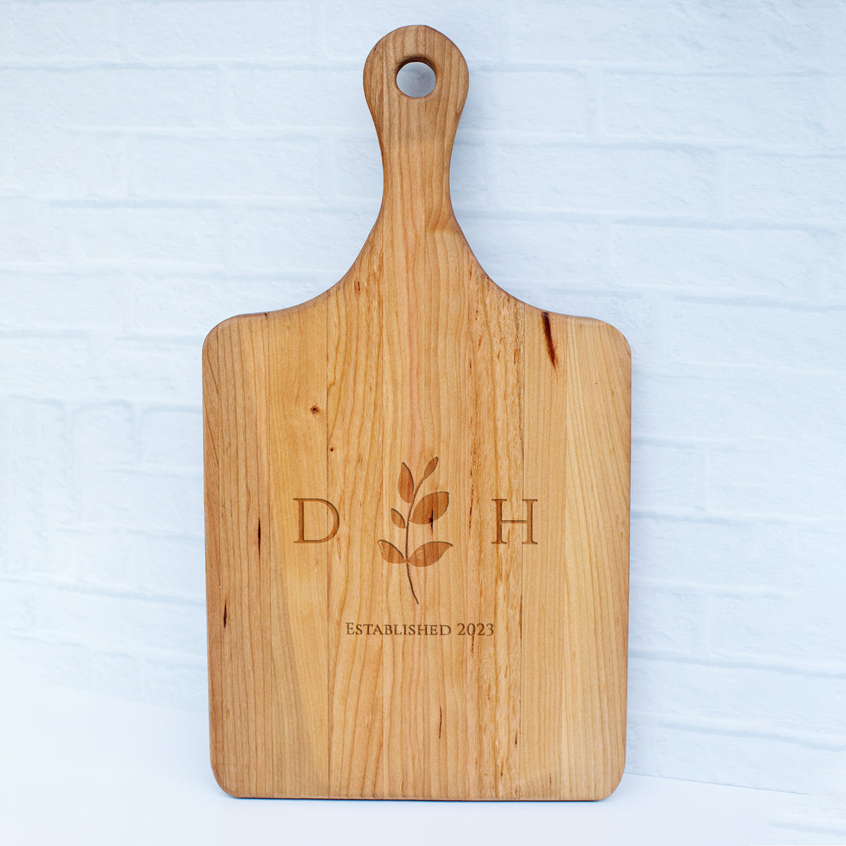a wooden cutting board with a flower on it