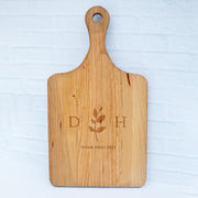 a wooden cutting board with a flower on it