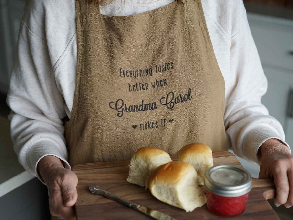 a woman holding a cutting board with rolls on it