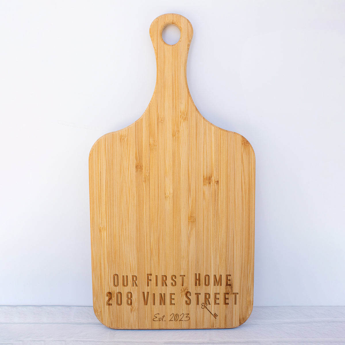 a wooden cutting board with the words our first home on it