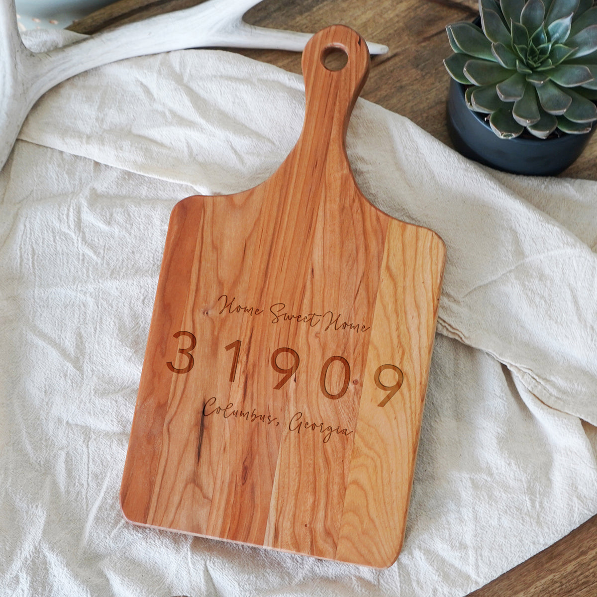 a wooden cutting board with a date engraved on it