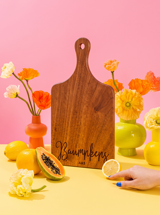 Modern Cursive Family Name Cutting Board in a colorful floral setting