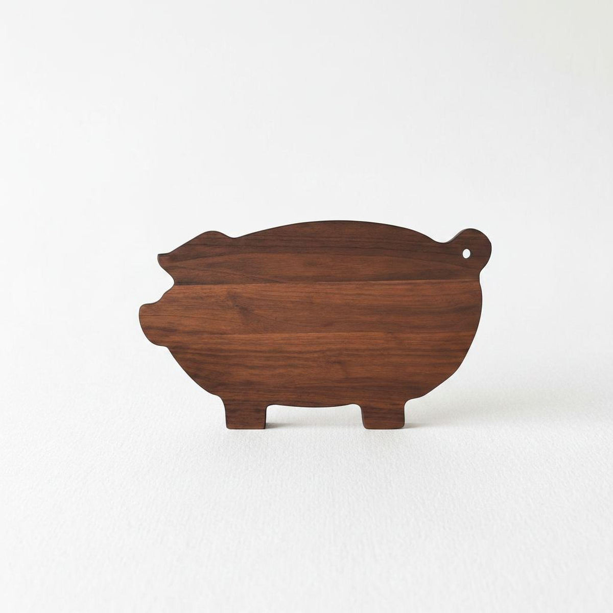A wooden pig-shaped cutting board is shown against a white background.