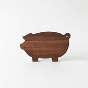 A wooden pig-shaped cutting board is shown against a white background.