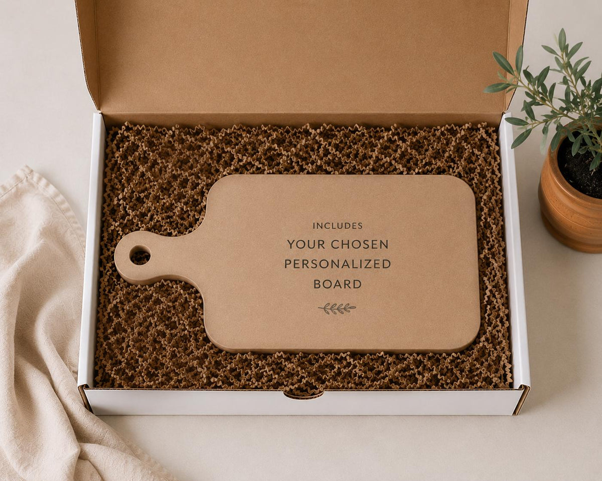 a cardboard box containing a wooden cutting board, with a potted plant and a cloth visible in the background.