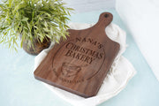 Holly Mixing Bowl edited mockup on a dark wooden handled board beside greenery and folded linen, personalized with Nana’s and Emma, Oliver and Lucy.