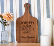 Joined in Faith engraving mockup on a small walnut handled board, with cross, Anna & Christopher and May 22, 2027.