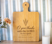Edited PSD composite mockup of a broad bamboo paddle board with the O give thanks wheat design and The Bennett Family personalization.