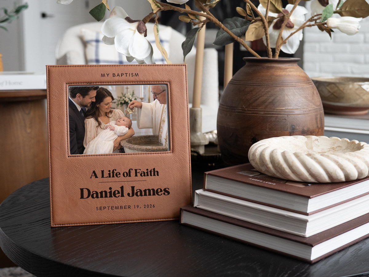 Edited mockup of the life of faith baptism frame beside flowers and books, with an illustrative baby baptism photo, Daniel James and September 19, 2026.