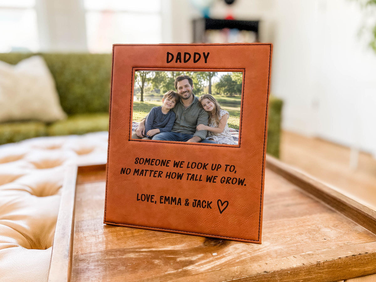 Edited mockup of the tall we grow Daddy frame on a tray, with a sample dad-and-children photo, engraved saying, Love, Emma & Jack signature and outline heart.