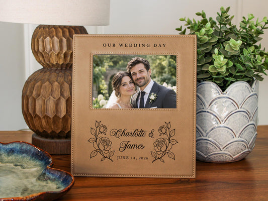 Wedding Roses frame mockup with a sample wedding photo, OUR WEDDING DAY, roses, Charlotte & James and June 14, 2026, beside a lamp and leafy plant.