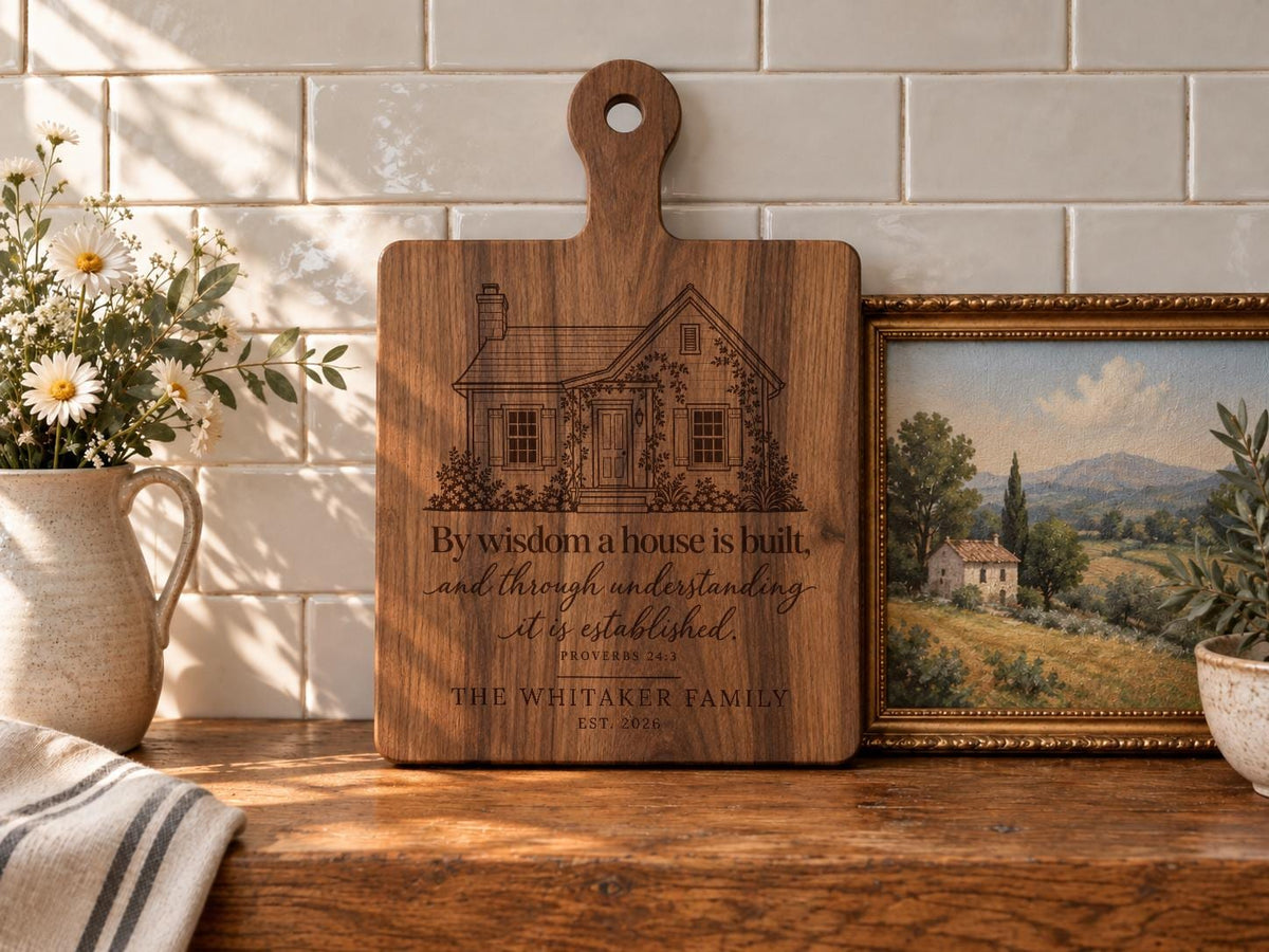 Edited mockup of a handled board with Proverbs Garden House engraving beside flowers and a framed landscape.