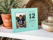 Teal Varsity Football frame mockup beside a potted plant and woven basket, with a sample football portrait and Jordan Miller number 12 personalization.