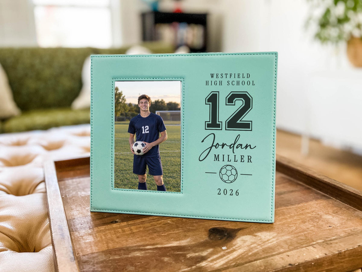 Edited Varsity Soccer frame mockup with an illustrative soccer player portrait on the left and sample Westfield High School, number 12, Jordan Miller and 2026 engraving on the right.