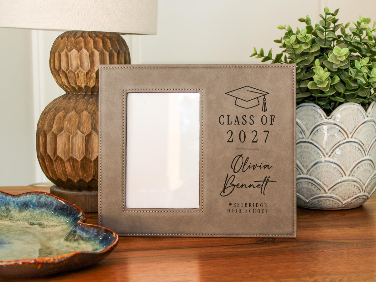 Grad Cap engraved frame reading Class of 2027, Olivia Bennett, Westbridge High School, with its original empty photo opening. Edited mockup with sample personalization.