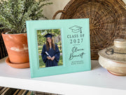 Grad Cap engraved frame reading Class of 2027, Olivia Bennett, Westbridge High School, with an illustrative graduation portrait. Edited mockup with sample personalization.