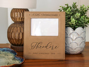 Edited mockup for Gift Options None: Christmas Wonder frame engraved with Theodore and First Christmas 2026, with the original empty photo opening and no inserted photo.