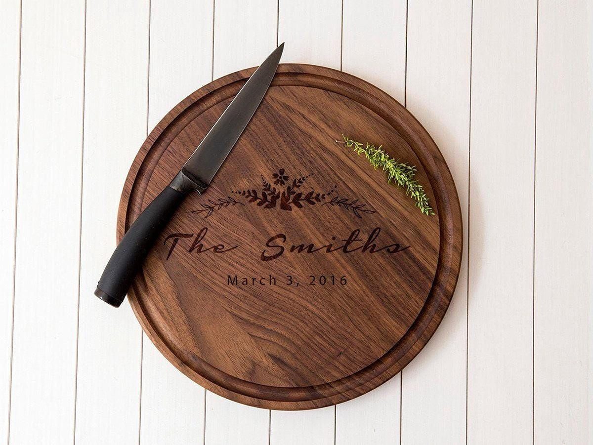 A wooden cutting board with a knife and a sprig of greenery on it, along with the text "The Smiths March 3, 2016" engraved on it.