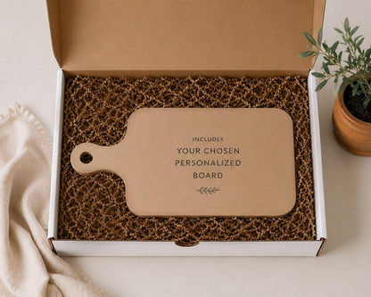 a cardboard box containing a wooden cutting board, with a potted plant and a cloth visible in the background.