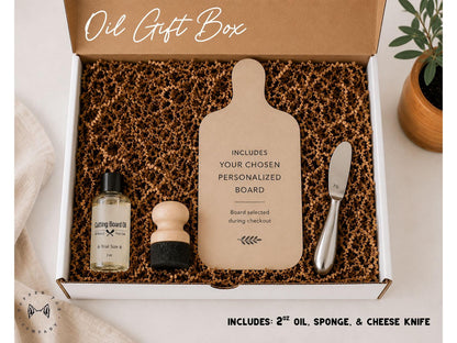 a gift box containing various items, including a cutting board, a bottle of oil, a sponge, and a cheese knife. The box is open, revealing the contents inside.