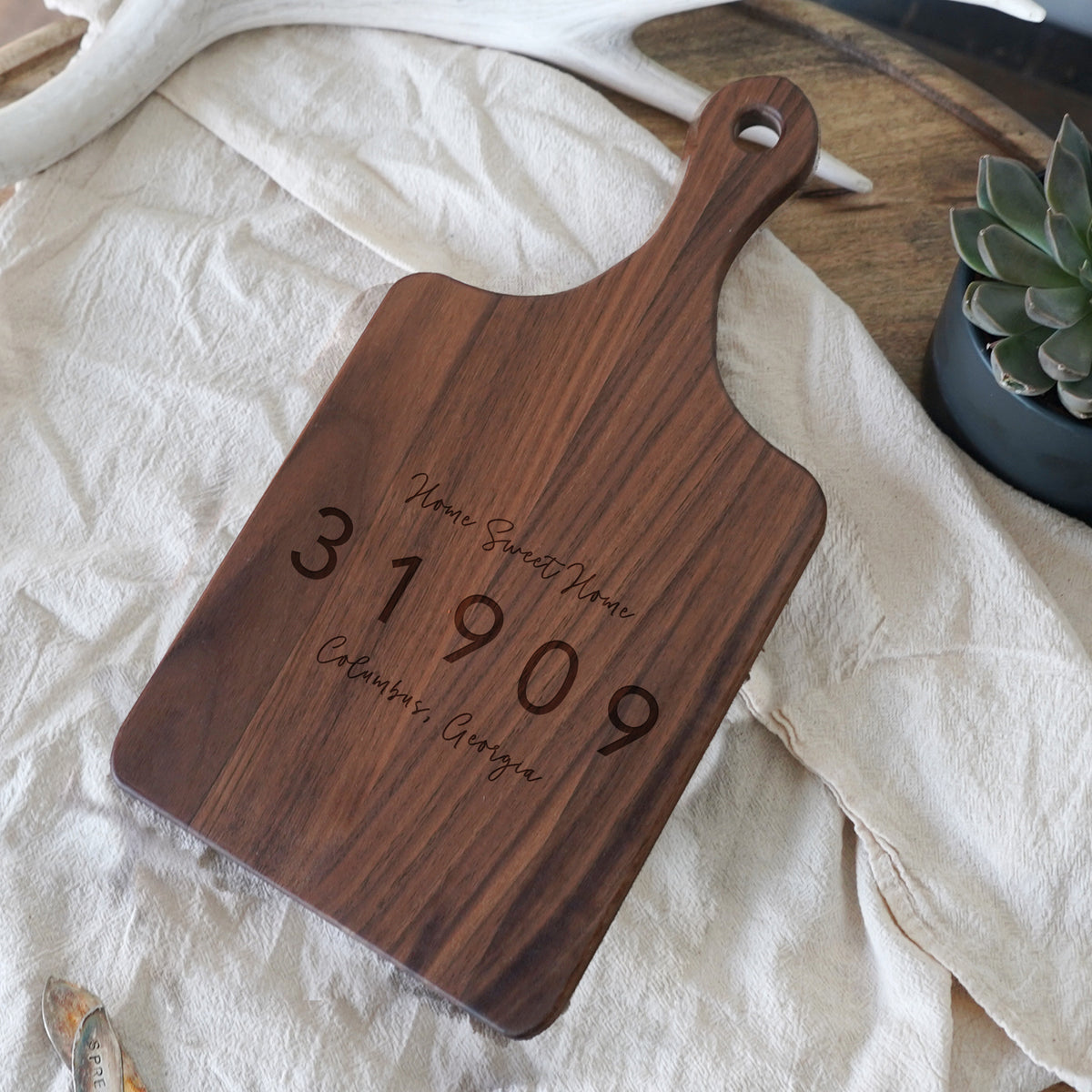 a wooden cutting board with a date engraved on it