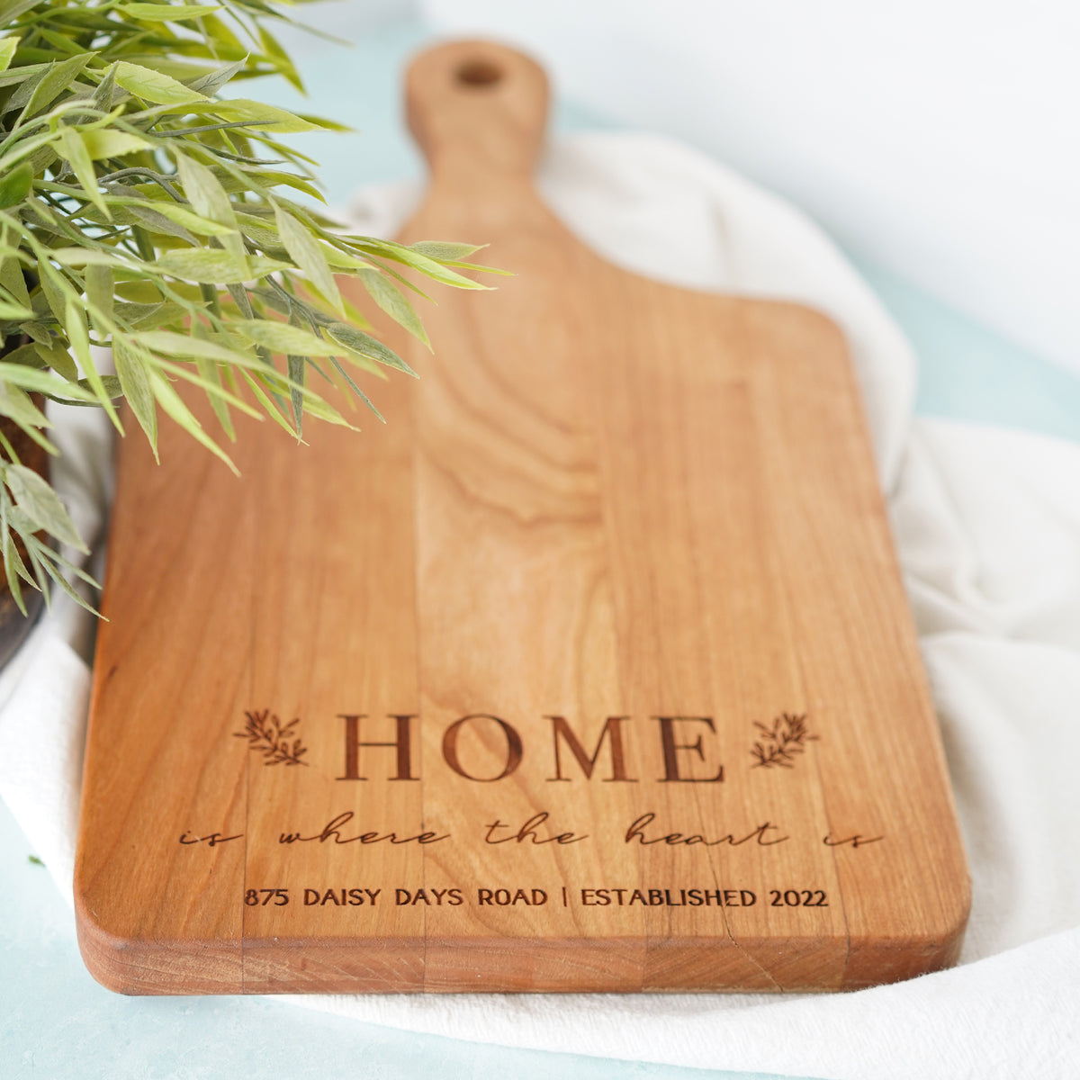 a wooden cutting board with the words home on it