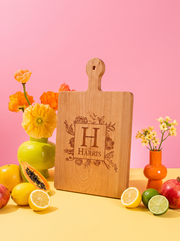 Floral Border Monogram Cutting Board in a colorful floral setting