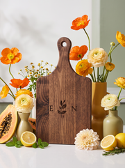 Ivy Initials Cutting Board in a colorful floral setting