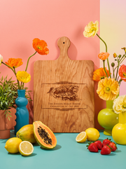 Coastal Wave Name Cutting Board in a colorful floral setting